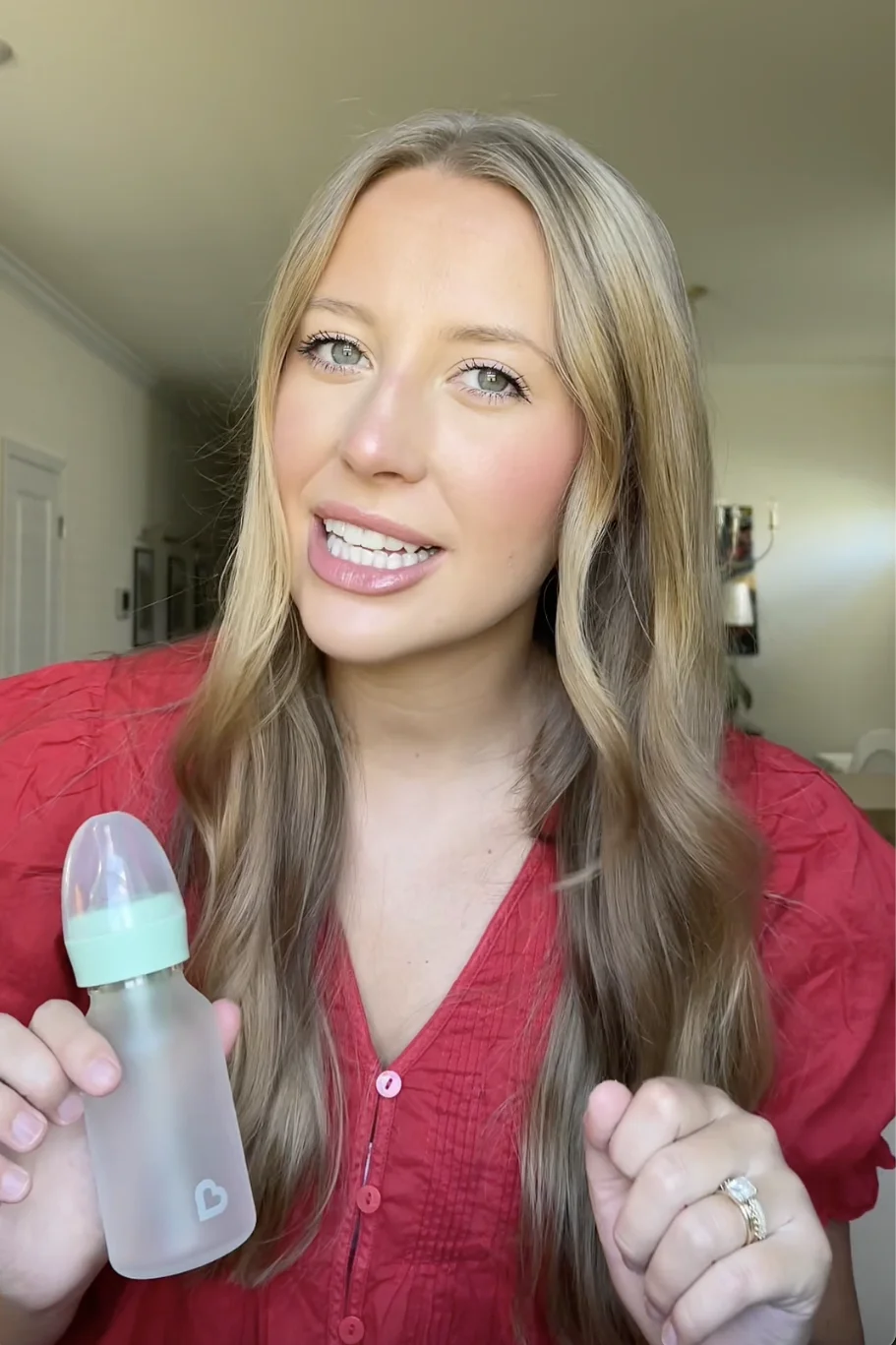 Creator in a red shirt holding a baby bottle